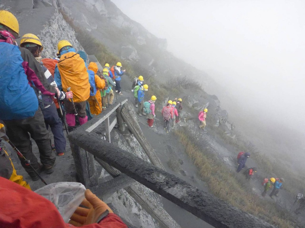 Climbers descend Mt. Ontake, which straddles Nagano and Gifu prefectures, to evacuate as volcanic ash falls at the mountain in central Japan